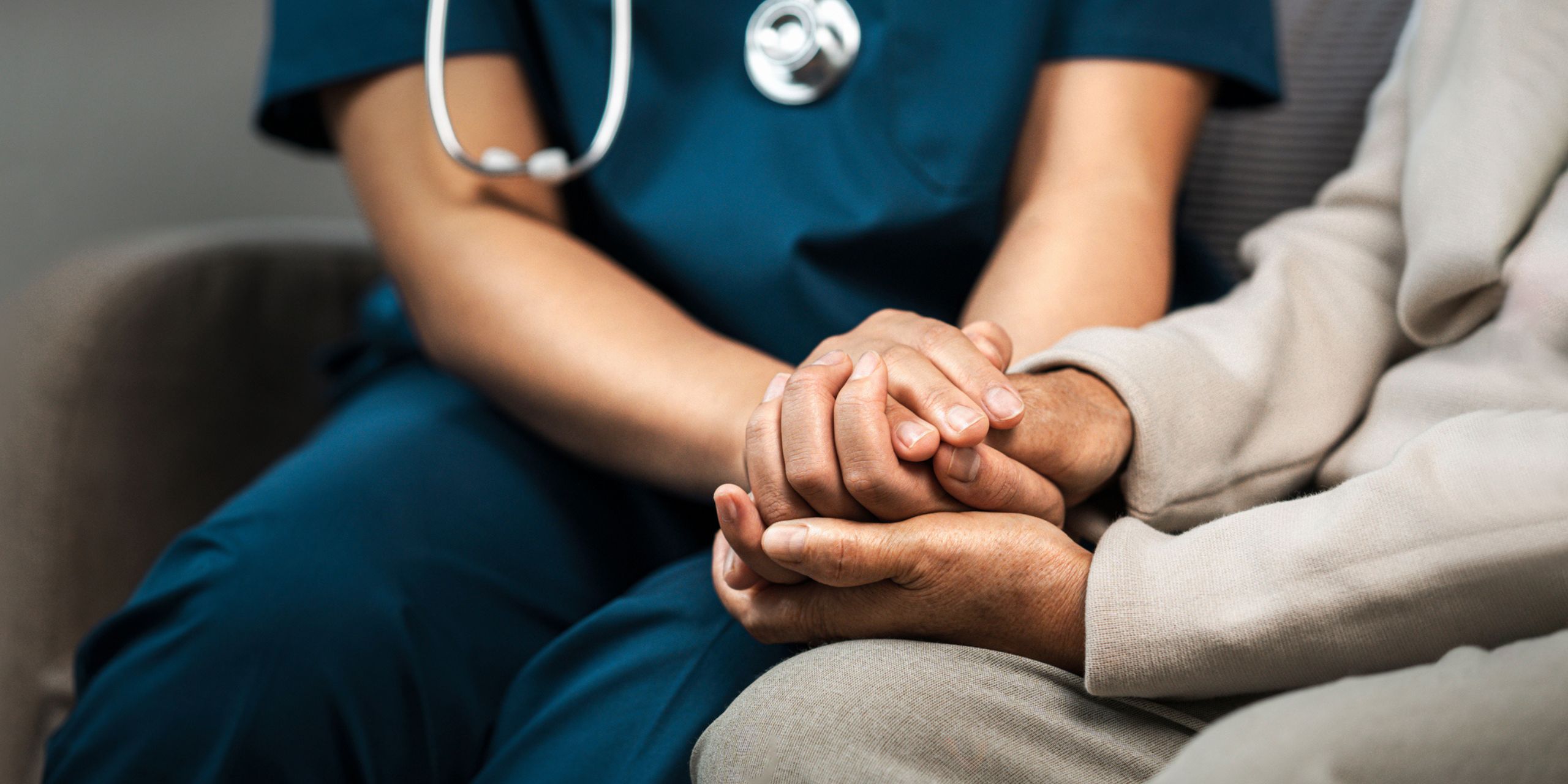 an aged care worker holding hands with an australian elder