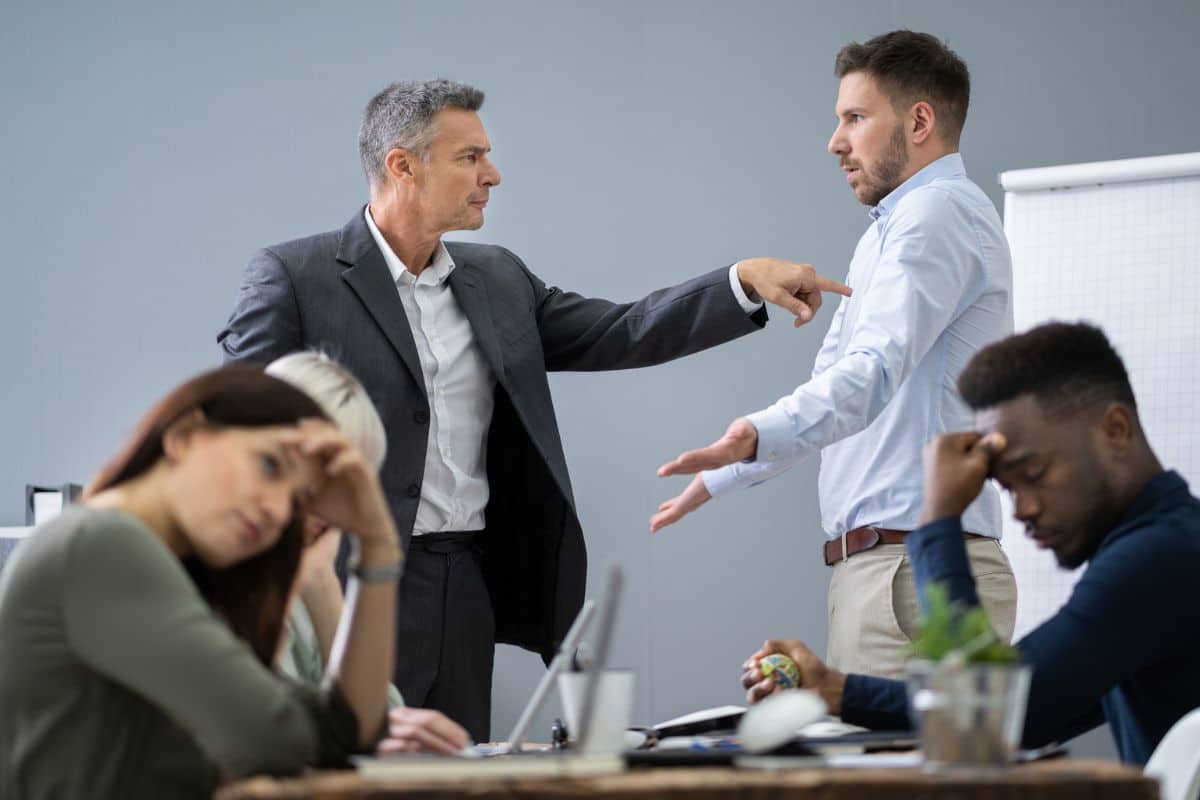a group of employees arguing to demonstrate a toxic work environment