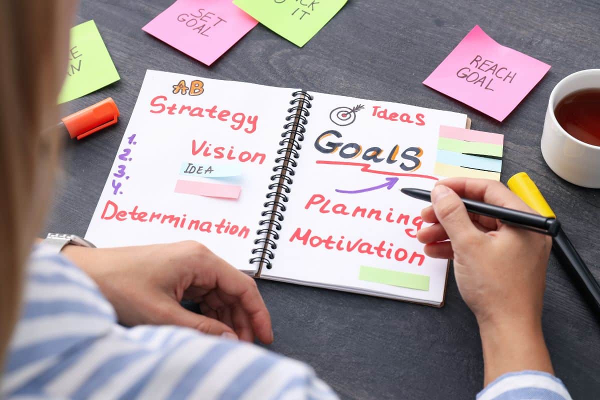 Manager plans training objectives in notebook
