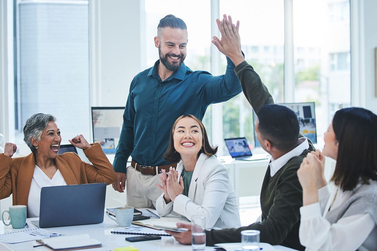diverse team members celebrate together in collaborating conflict management style