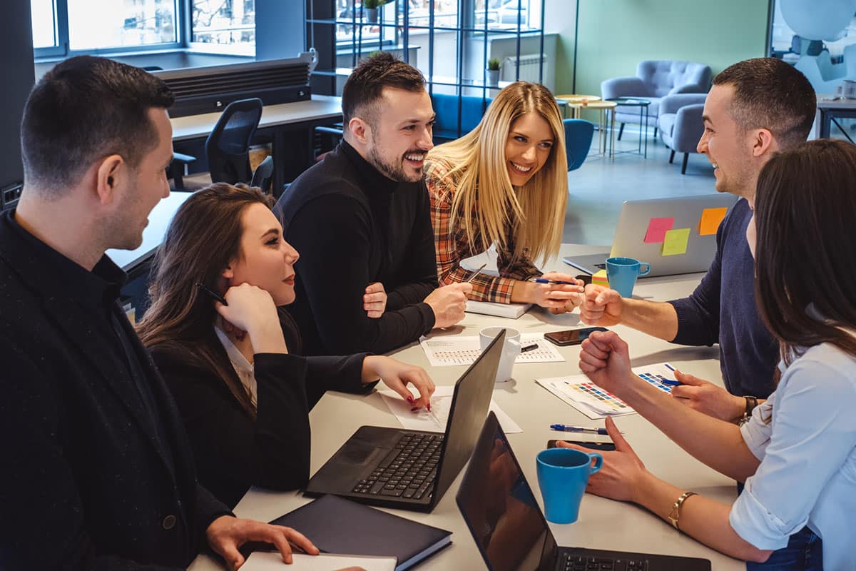 colleagues laugh together during meeting highlighting emotional intelligence in dealing with situations