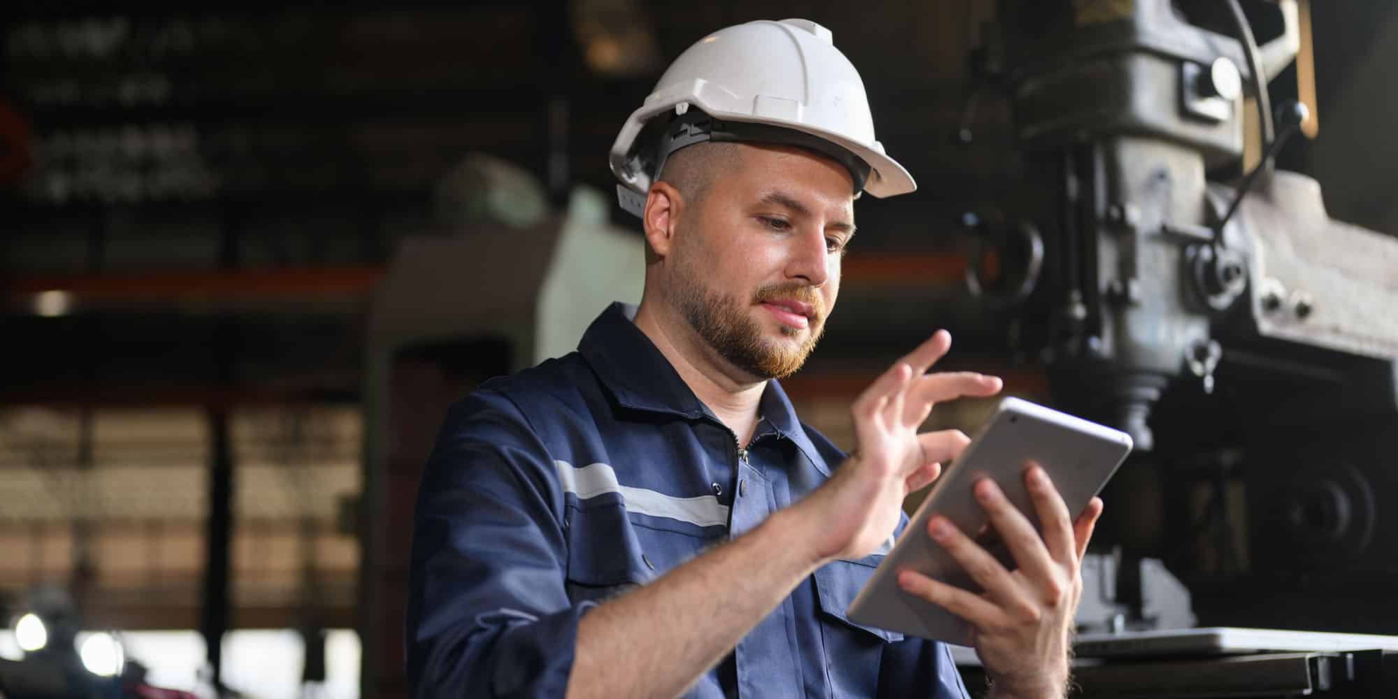 manufacturing worker completes competency assessment on tablet