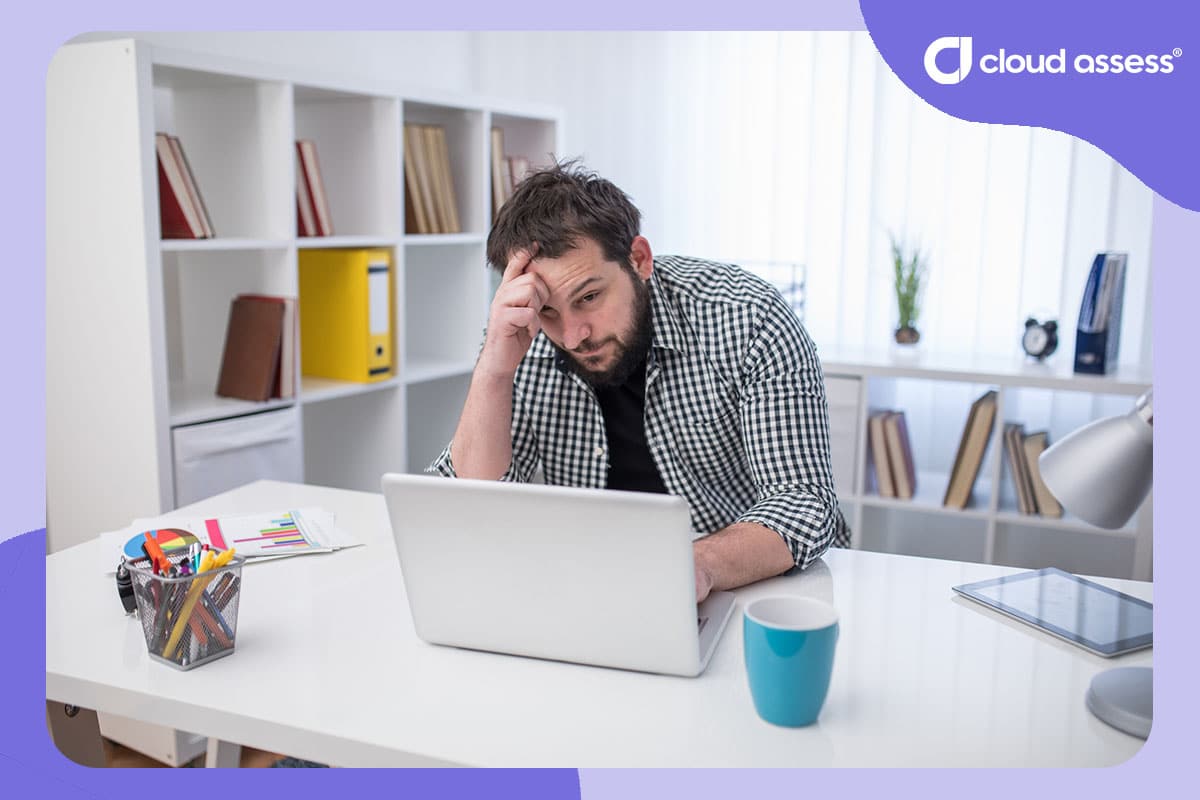 man looks stressed and frustrated while working on laptop