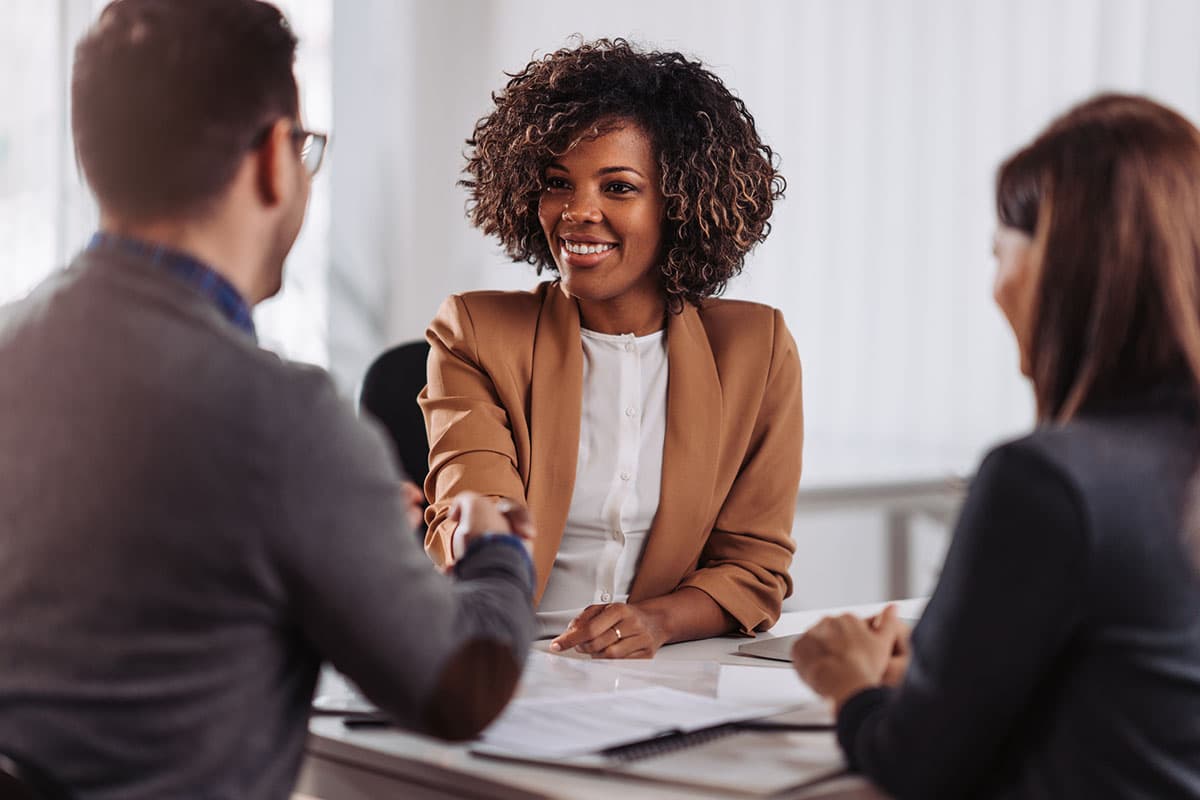 newly hired business woman shakes hand with man in suit