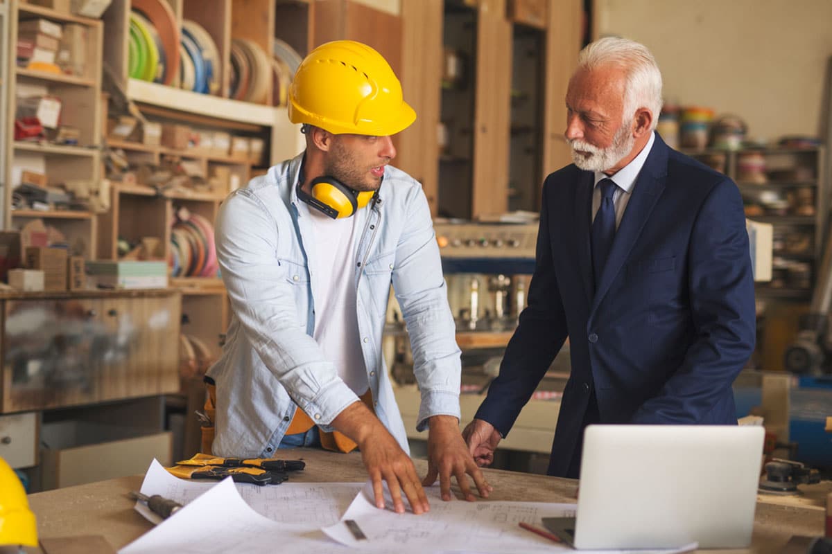 older man and younger man discuss building details as part of succession planning