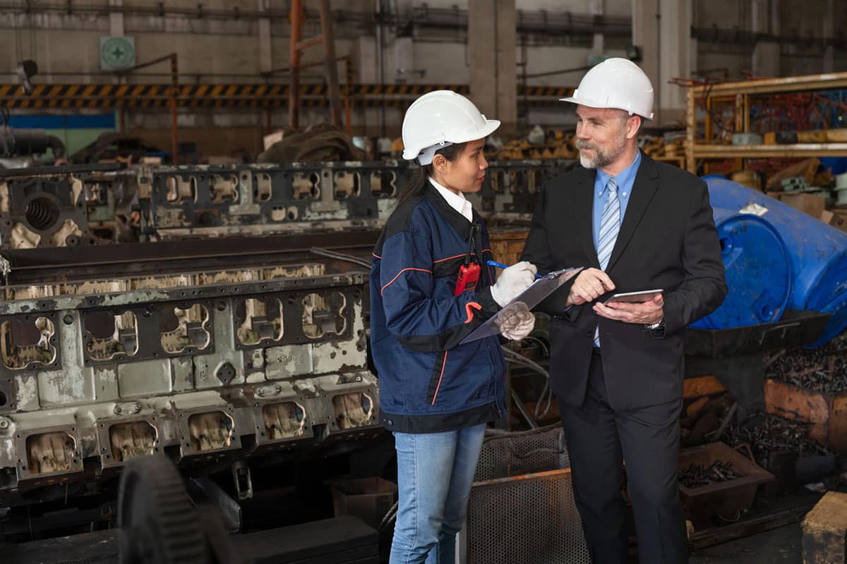 older man teaches younger woman how machinery works as part of succession planning