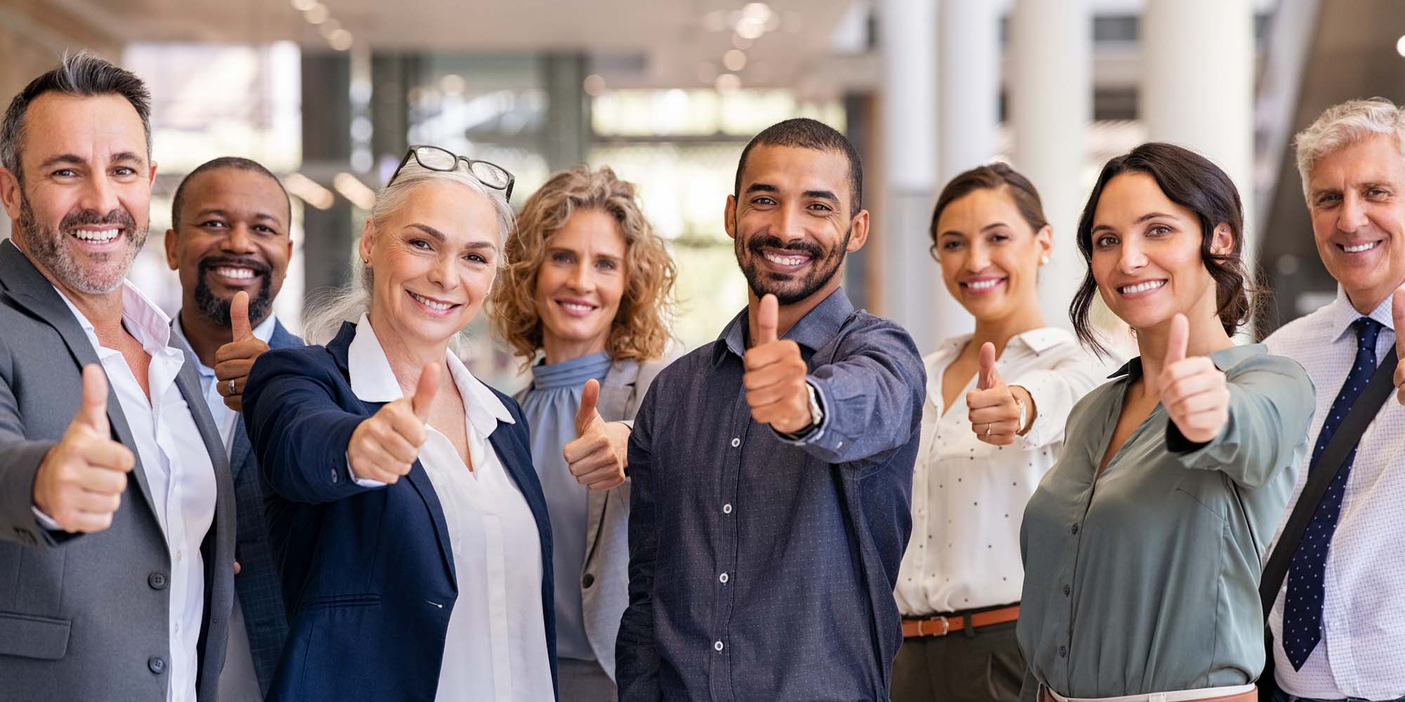 diverse team hold out thumbs up as part of giving feedback on training