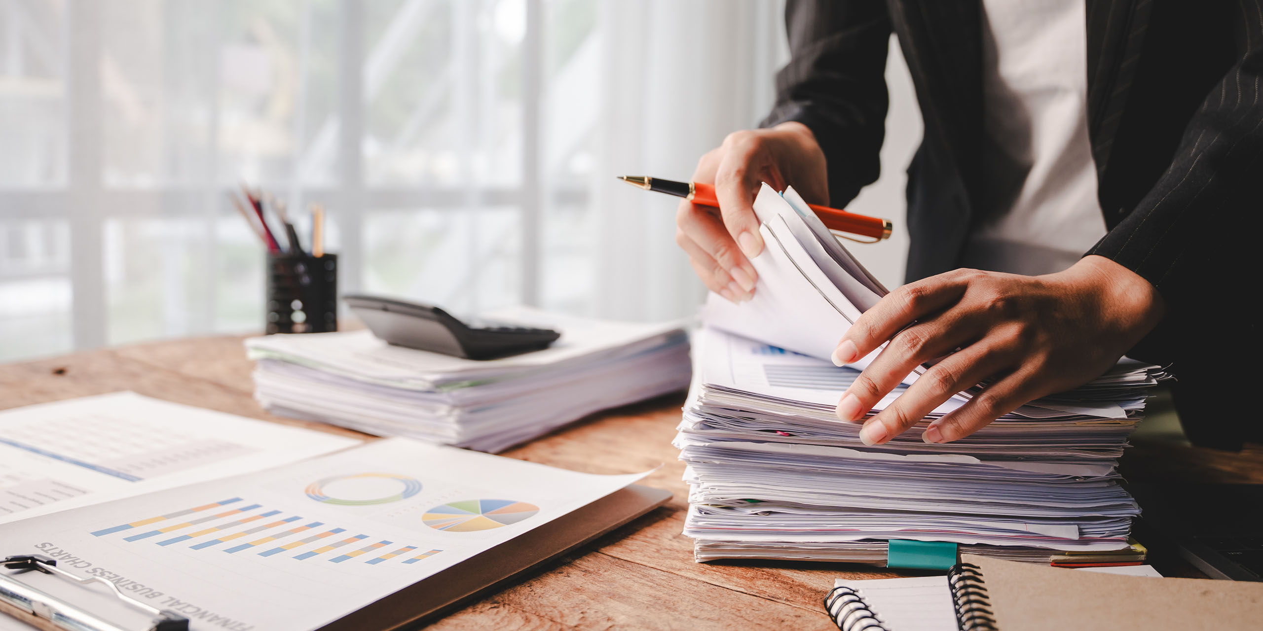 trainer sorts through piles of assessments on her desk