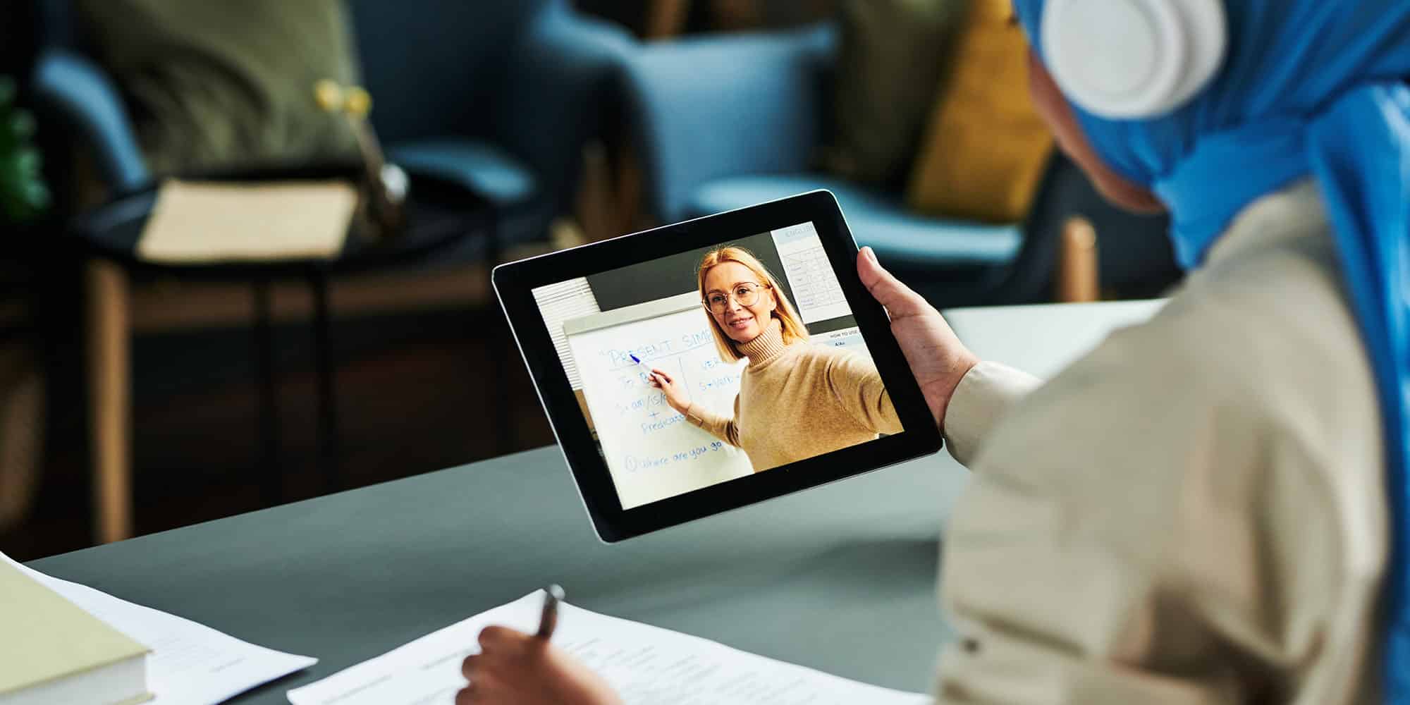 woman participating in virtual learning environments on her tablet