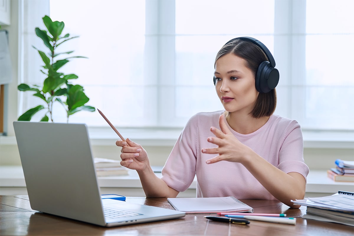 woman with headphones using laptop for change management training course